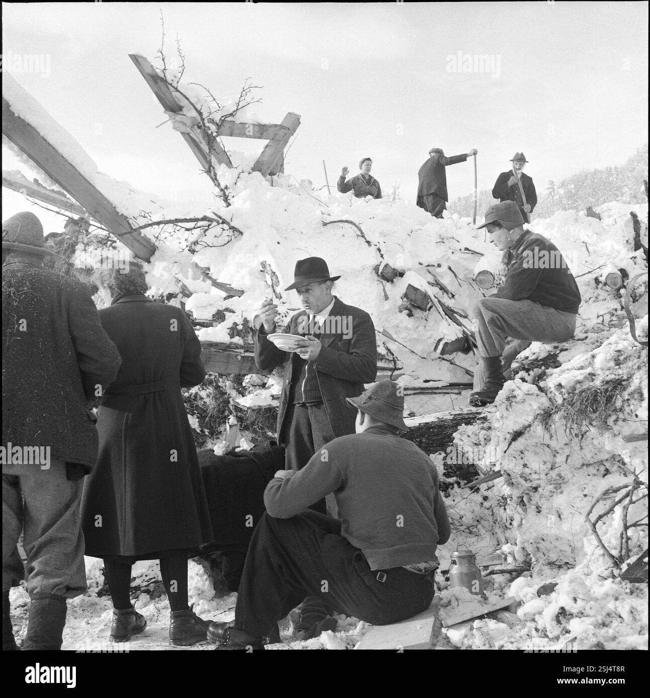 --- Männer machen Pause während Räumungsarbeiten nach Lawinenniedergang im Montafontal; 1954#Avalanche im Montafontal, Männer, die bei Räumungsarbeiten eine Pause machen; 1954 Stockfoto