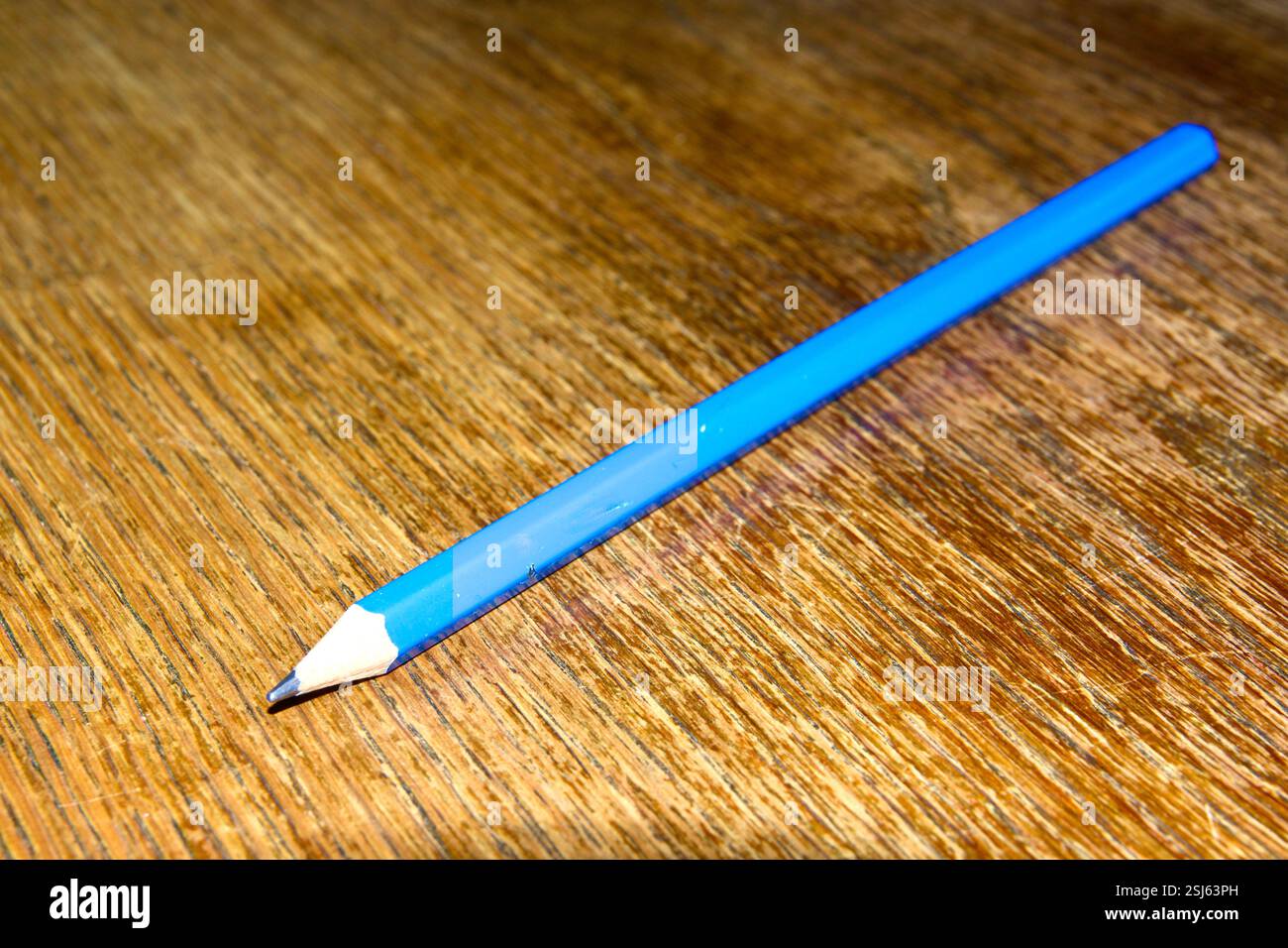 Blauer Bleistift auf einem Tisch aus Eichenholz. Nahaufnahme Stockfoto