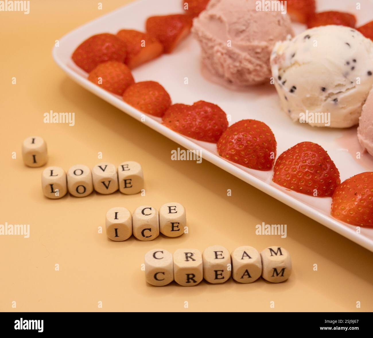 Ein Teller mit Eiskugeln und Erdbeeren für Eis am Frühstückstag. Stockfoto