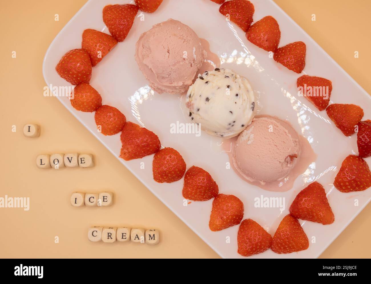 Ein Teller mit Eiskugeln und Erdbeeren für Eis am Frühstückstag. Stockfoto