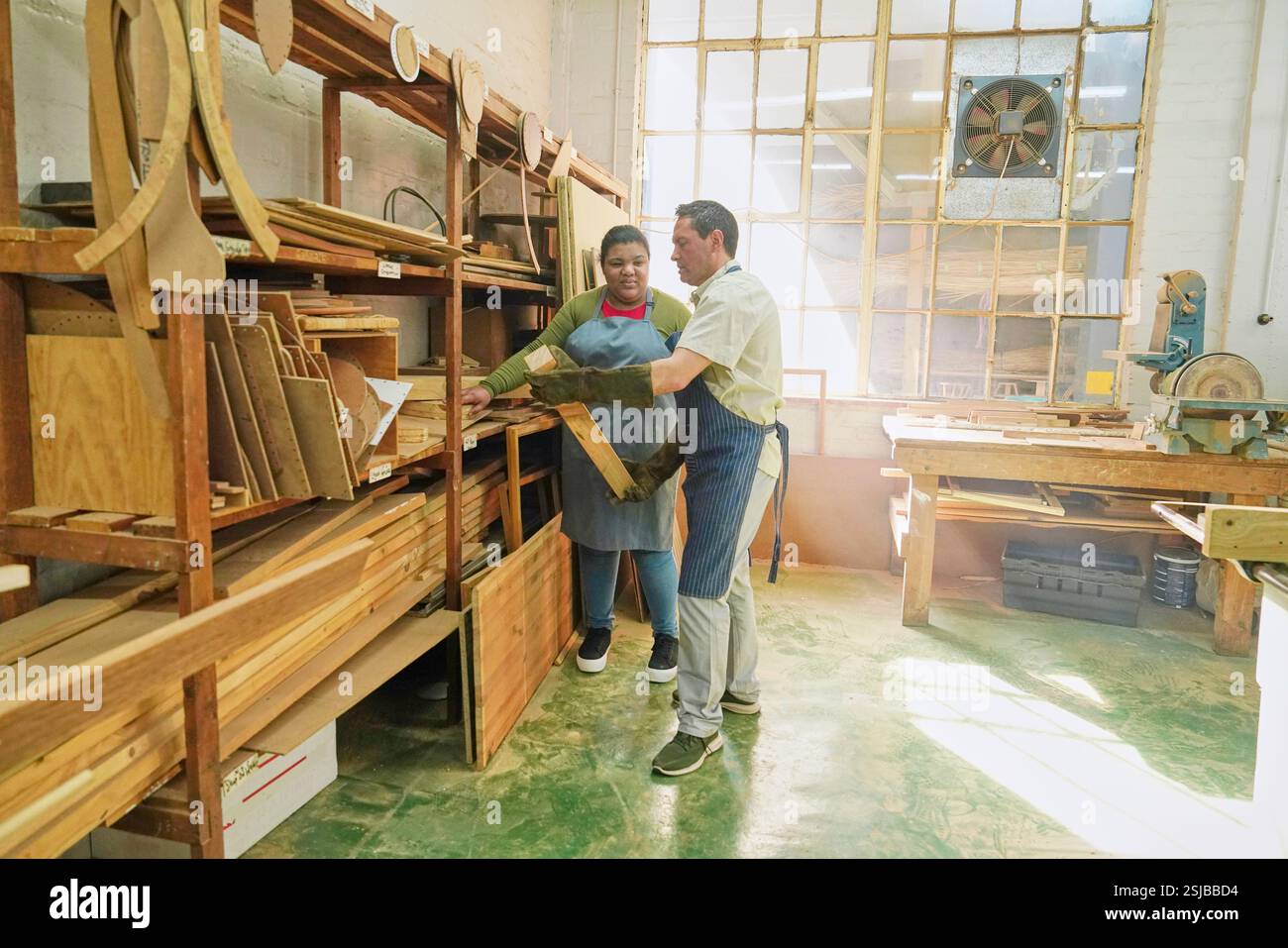 Zwei Handwerker, die Holzdielen in Holzwerkstatt nehmen Stockfoto