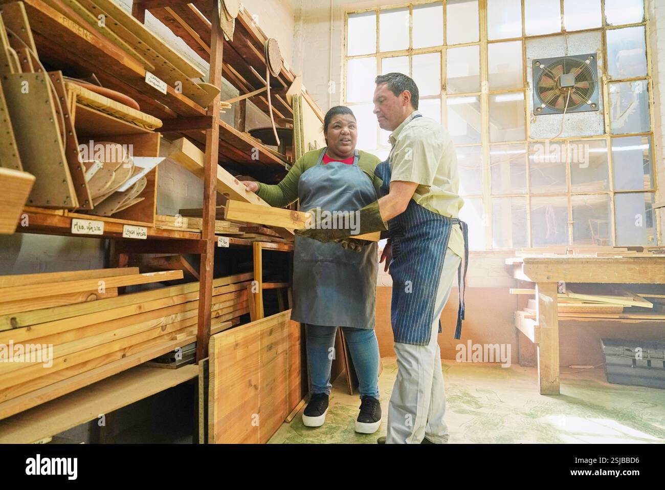 Zwei Handwerker, die Holzdielen in Holzwerkstatt nehmen Stockfoto