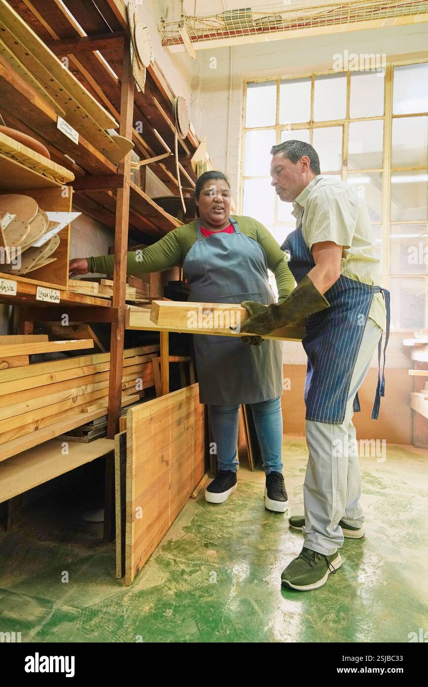 Zwei Handwerker, die Holzdielen in Holzwerkstatt nehmen Stockfoto