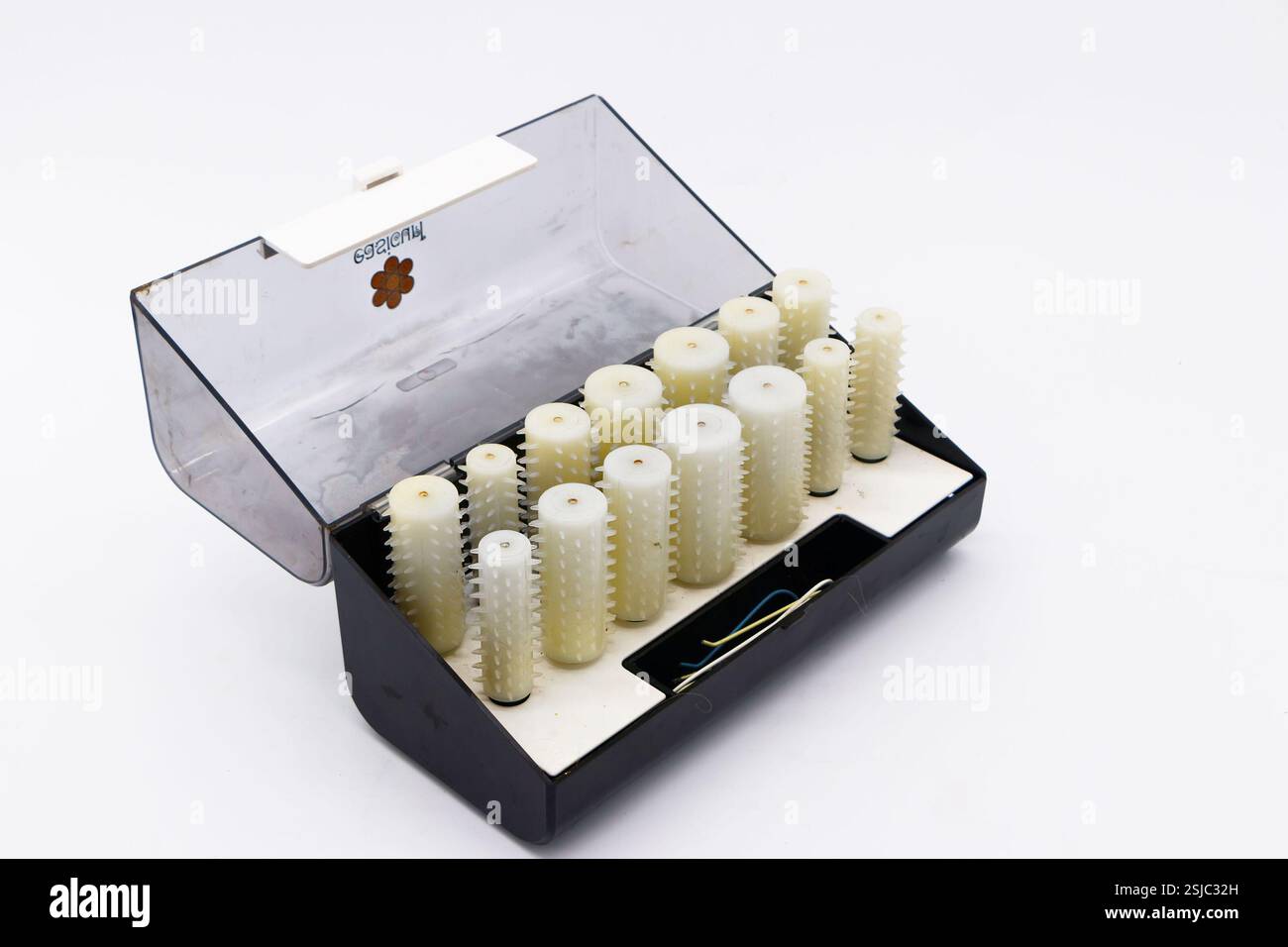 Set von Vintage weißen Carmen Kunststoff beheizten Lockenwickler Rollen in einem offenen schwarzen Aufbewahrungsbehälter auf weißem Hintergrund Stockfoto