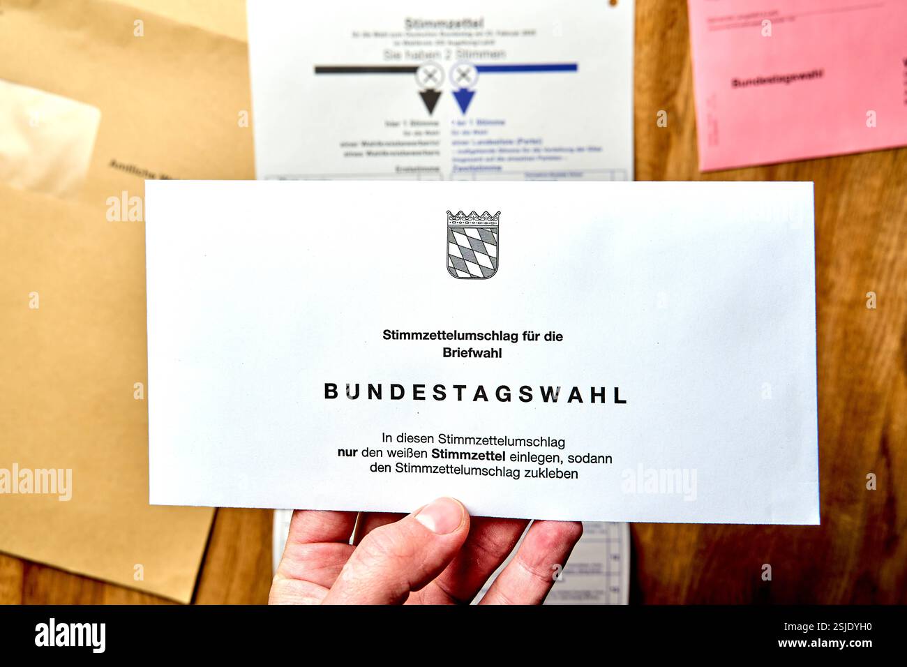 Bayern, Deutschland - 11. Februar 2025: Mann hält Stimmzettelumschlag ...