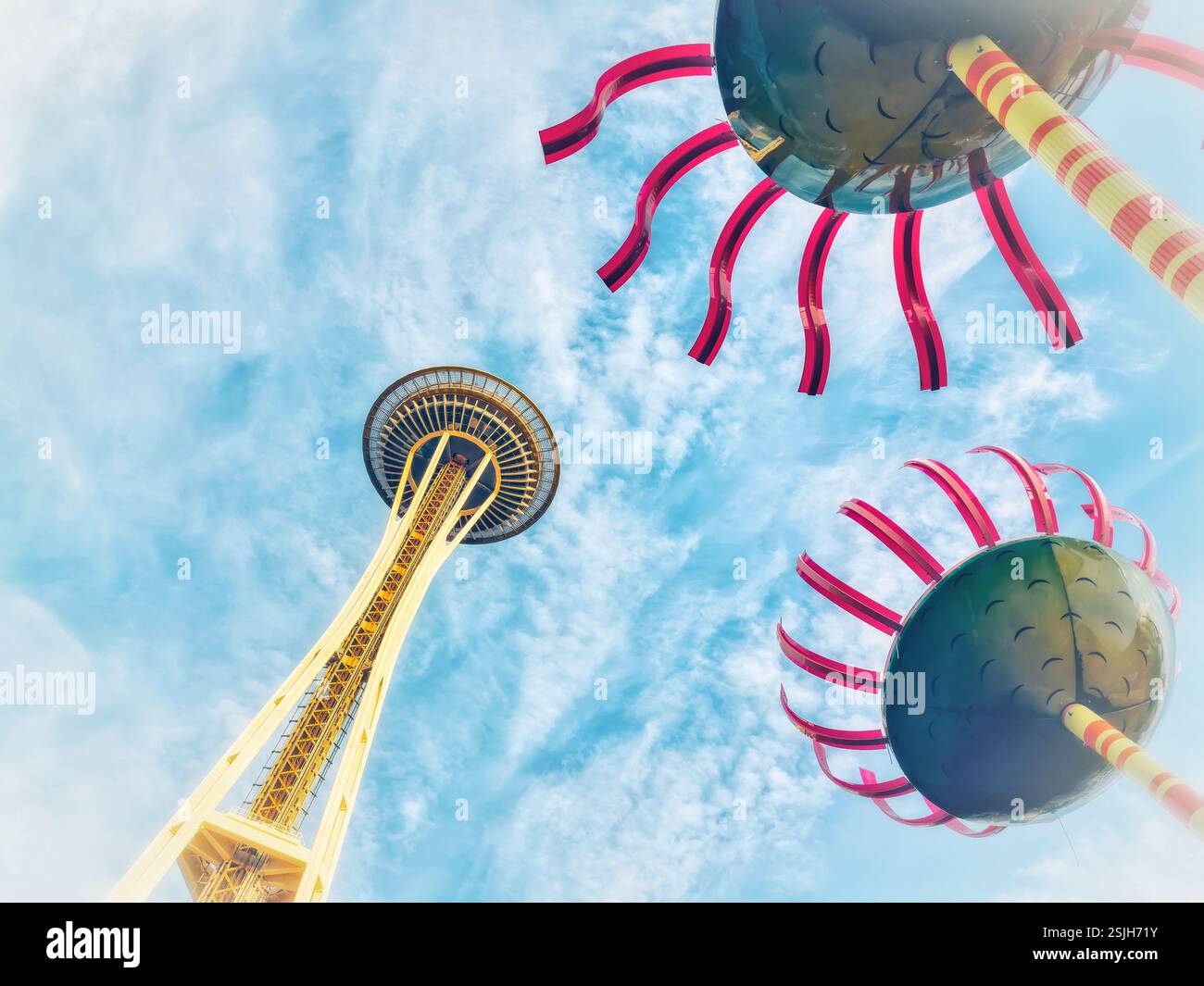 Bei einer Niedrigwinkelaufnahme wird die legendäre Space Needle in Seattle, Washington, vor dem Hintergrund eines hellblauen Himmels mit flauschigen weißen Wolken gefangen. Stockfoto