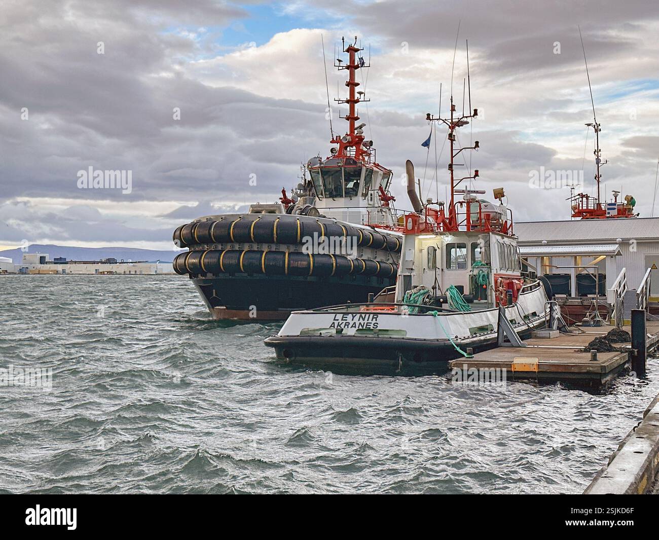 Reykjavík, Island - 21. August 2024: Schlepper und kleines Boot im Hafen von Reykjavík - Smartphone-aufgenommenes Stockfoto