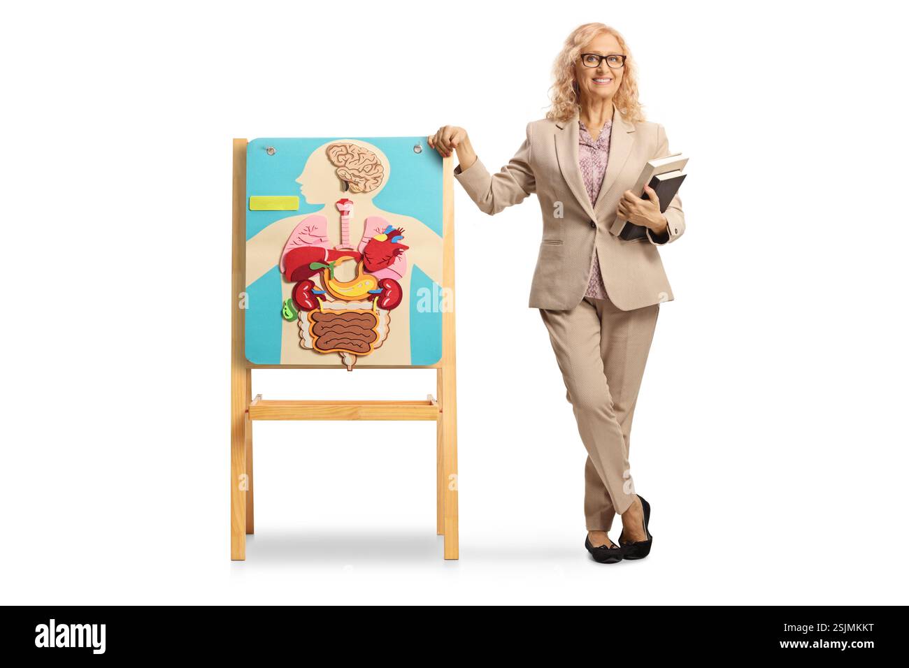 Porträt einer Biologielehrerin in voller Länge, die neben einem Brett steht, mit einem Poster mit inneren menschlichen Organen isoliert auf weißem Hintergrund Stockfoto