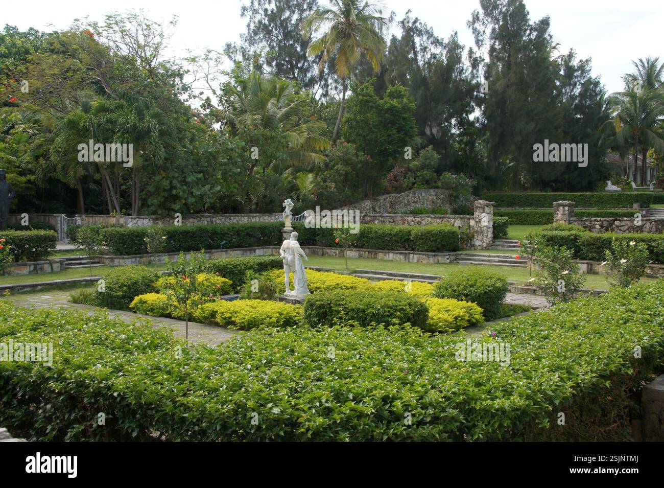 Formeller italienischer Garten auf den Bahamas. Symmetrisches Layout mit gepflegten Hecken und modellierten Formteilen. Steinmauern und Statuen vermitteln ein Gefühl von gran Stockfoto