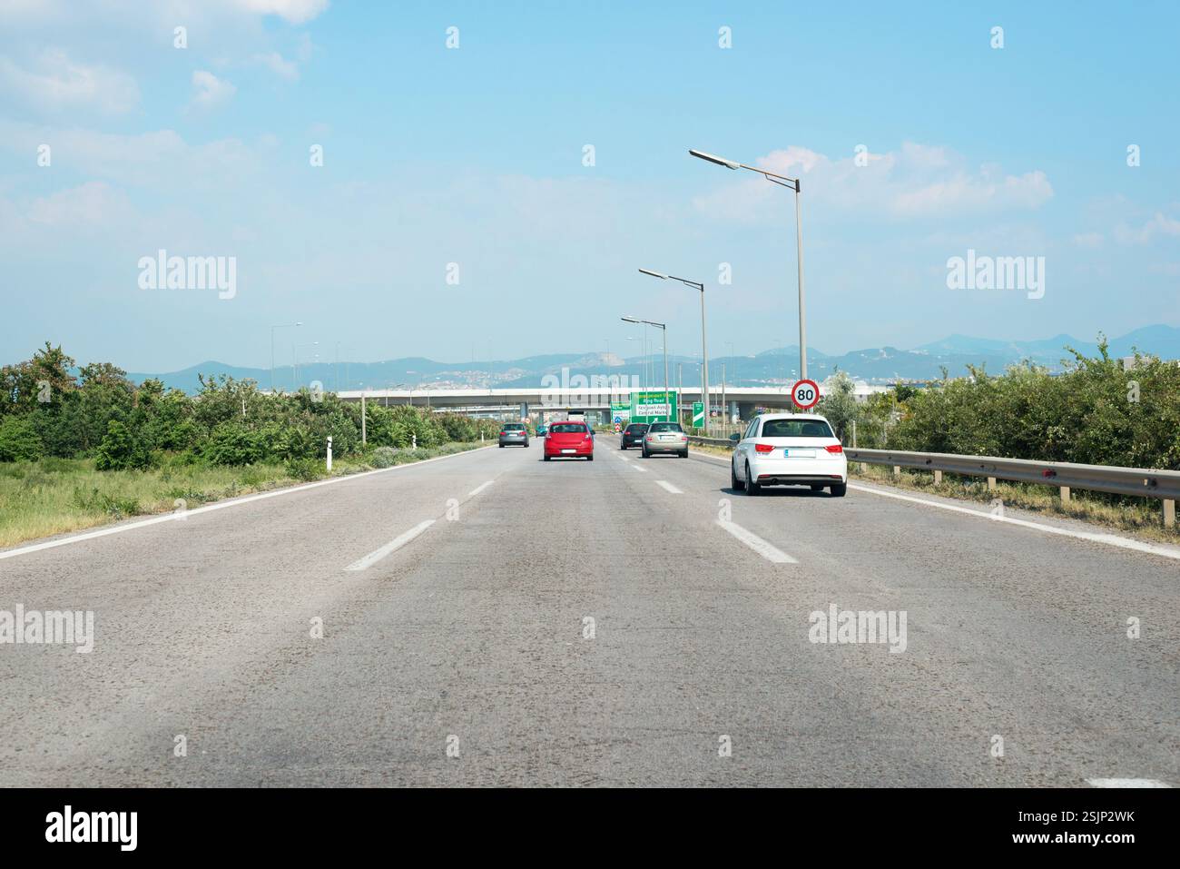 Fahren Sie auf einer Autobahn mit mediterranen Landschaften, erfassen Sie den Verkehrsfluss und die Infrastruktur, und betonen Sie den Transport in Südeuropa Stockfoto
