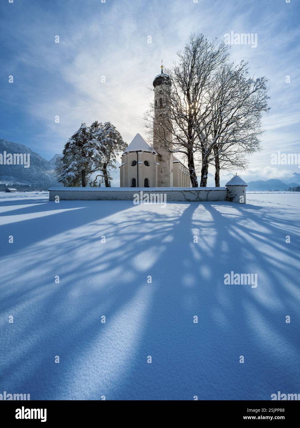 Die Wallfahrtskirche St. Coloman in einer schneebedeckten Landschaft im Winter hinterleuchtet, Schwangau, Allgaeu, Bayern, Deutschland, Europa Stockfoto