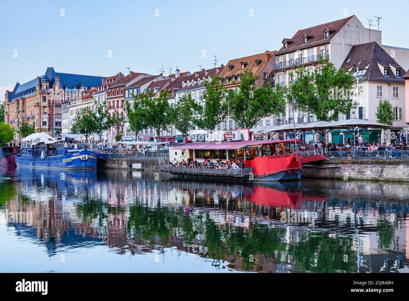 Die Leute gehen nach Straßburg und besuchen Restaurants auf Booten. Elsass, Frankreich. Stockfoto