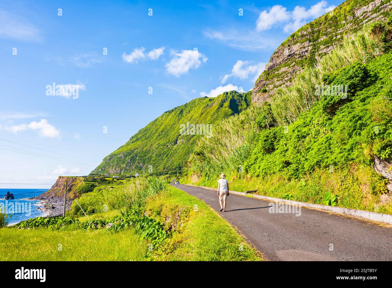 Junge Frau, die am Meer entlang läuft, im Dorf Faja Grande, Flores, Azoren, Portugal Stockfoto