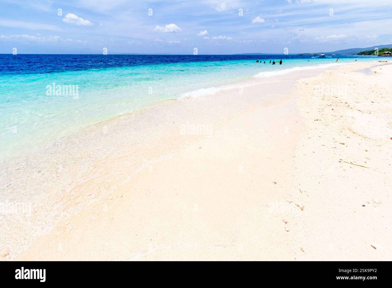 Weißer Sandstrand und smaragdgrüner Wasser sind ein beliebtes Touristenziel auf Samal Island, Philippinen, bekannt für seine unberührte Küste und tropische Schönheit Stockfoto