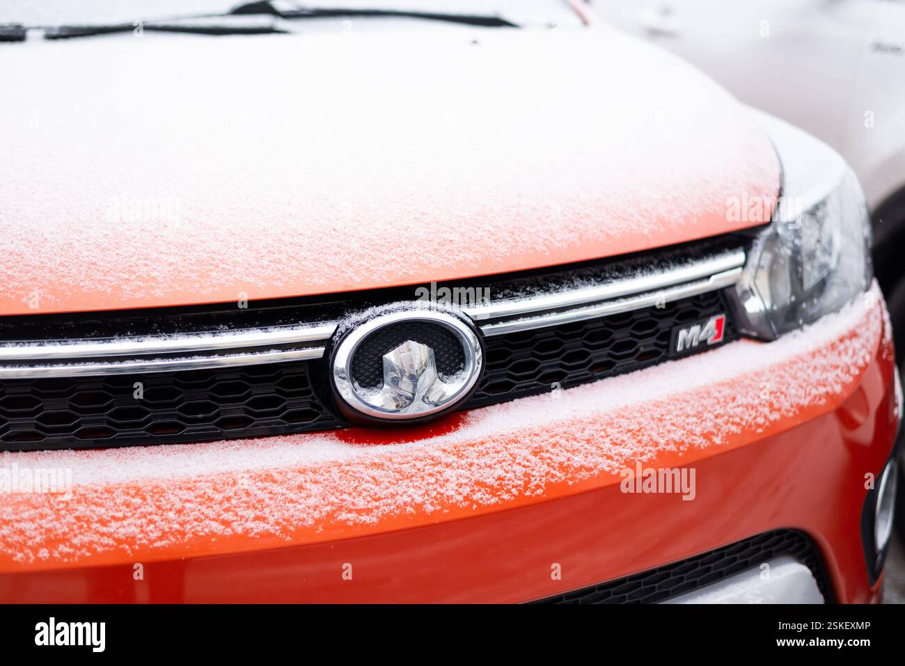 Kiew, Ukraine, 11. Februar 2025. Nahaufnahme eines Kühlergrills und Emblems der Great Wall Haval M4, teilweise mit Neuschnee bedeckt. Stockfoto