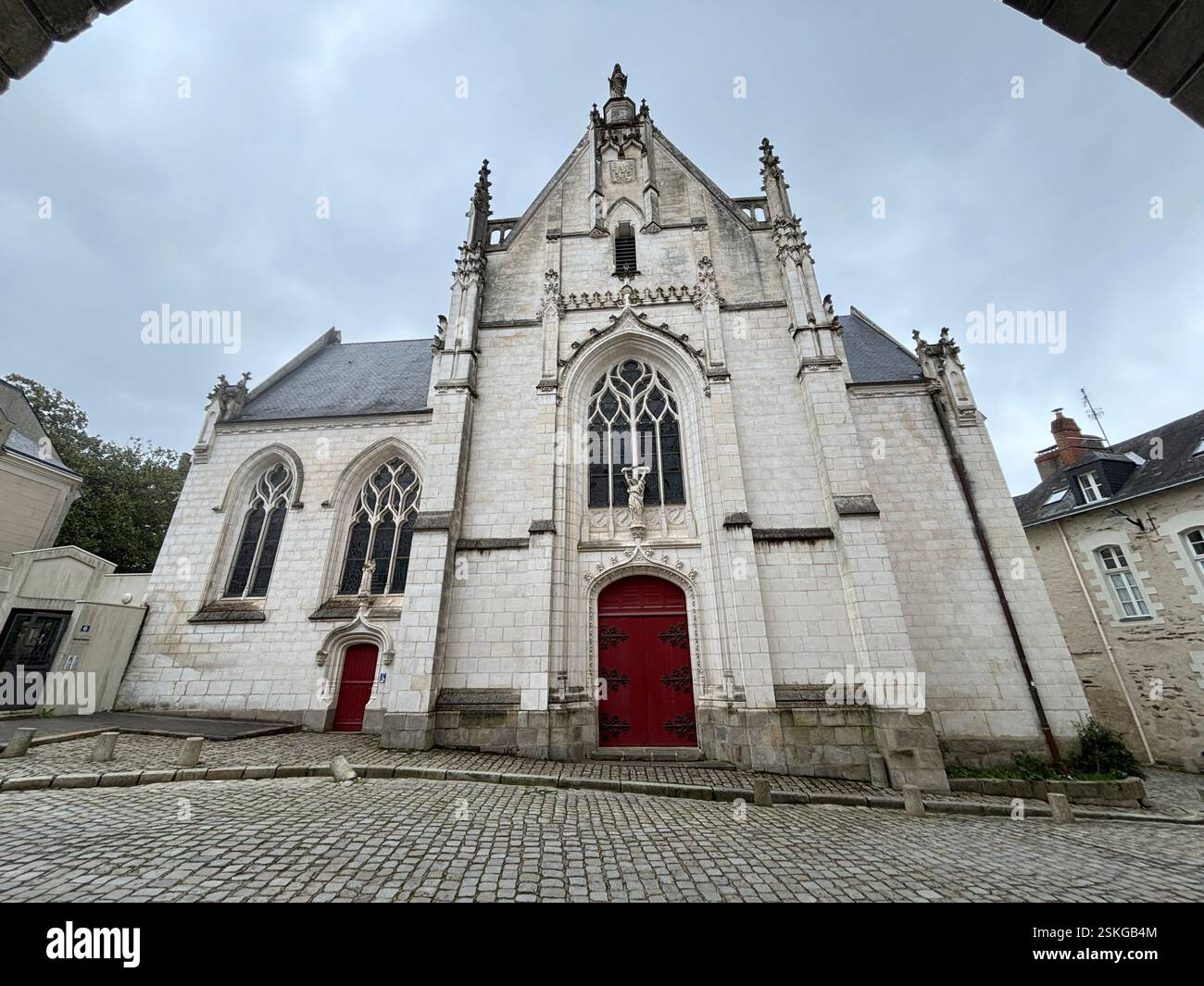 Alte Steinkirche im gotischen Stil in Nantes, Frankreich. Bewölkter Tag. Hoch aufragender Turm. Alte Architektur. Religiöses Gebäude - Smartphone-aufgenommenes Stockfoto
