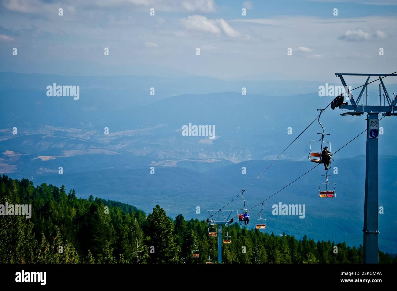 BULGARIEN: Skilift, die eine Bergkette hinaufführt. Blauer Himmel mit weißen Wolken. Üppige grüne Wälder darunter. Ein Gefühl von Freiheit und Abenteuer. Das Bildsymbol Stockfoto
