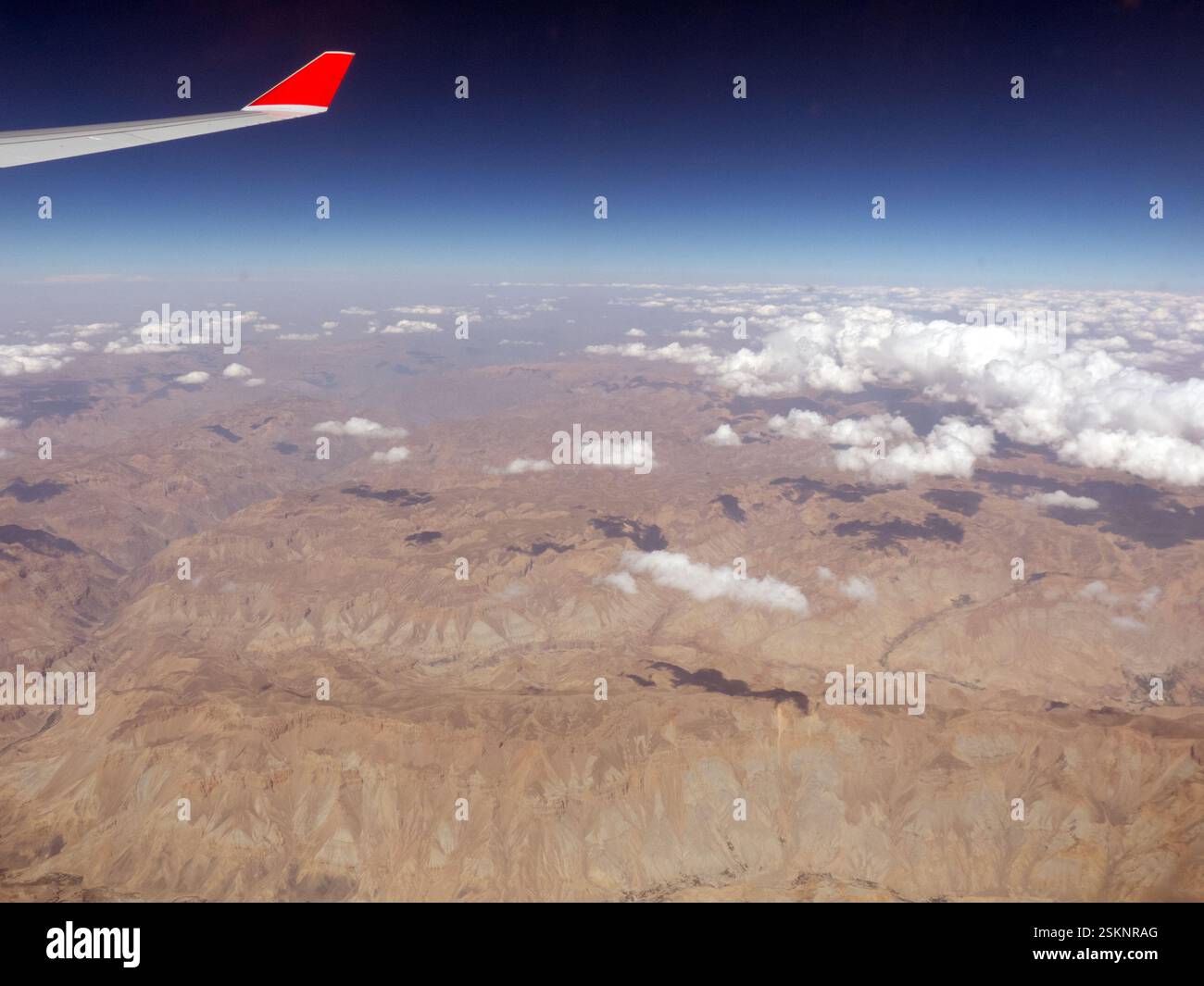 Luftaufnahme eines Flugzeugflügels über abgelegener Berglandschaft, Afghanistan Stockfoto