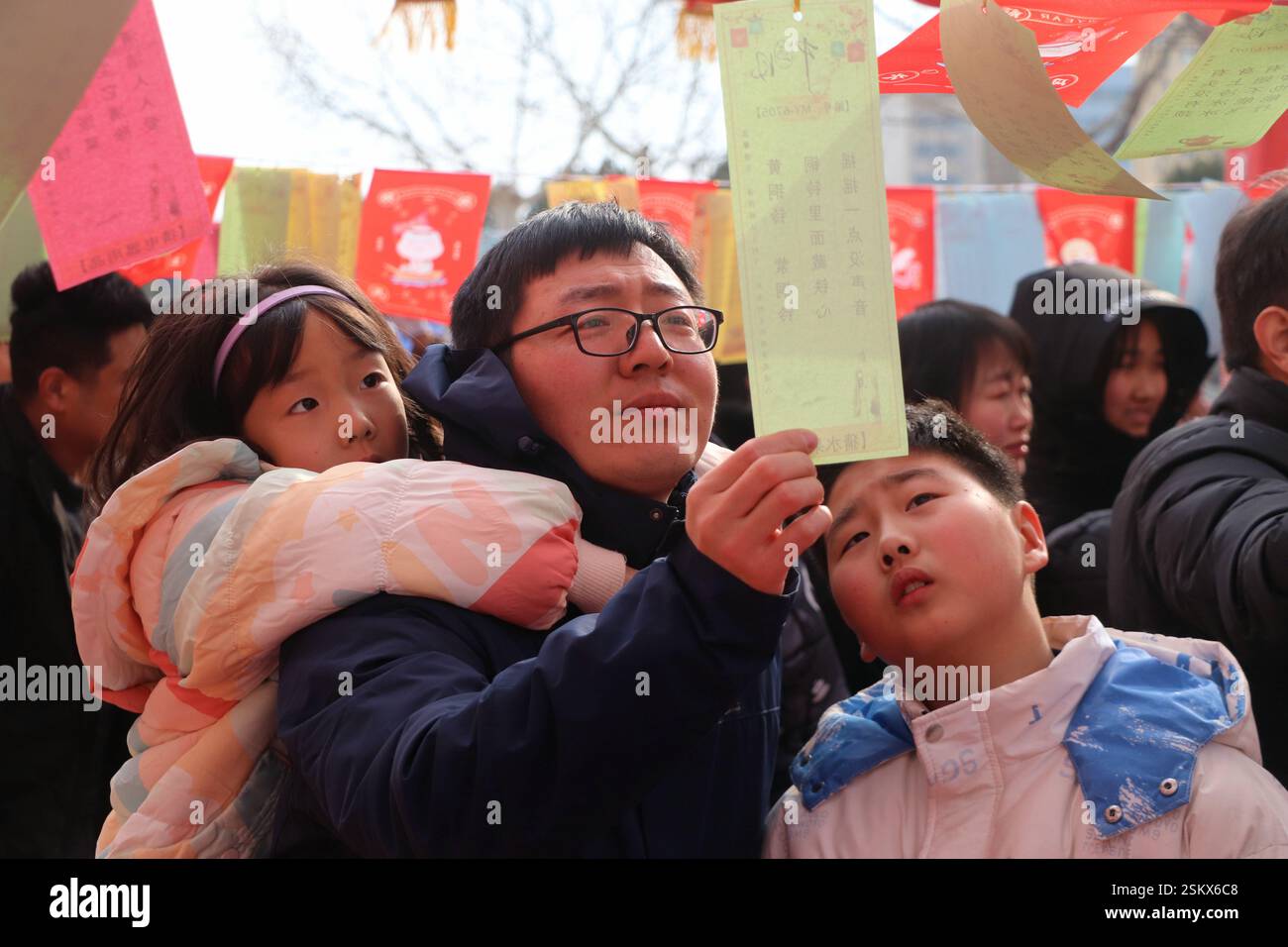 PEKING, 12. Februar 2025 -- Eltern und Kinder erraten Laternen-Rätsel in Gaomi, ostchinesischer Provinz Shandong, 12. Februar 2025. In ganz China fanden verschiedene Aktivitäten statt, um das Laternenfest zu feiern, das auf den fünfzehnten Tag des ersten Monats des chinesischen Mondkalenders fällt. (Foto: Li Haitao/Xinhua) Stockfoto