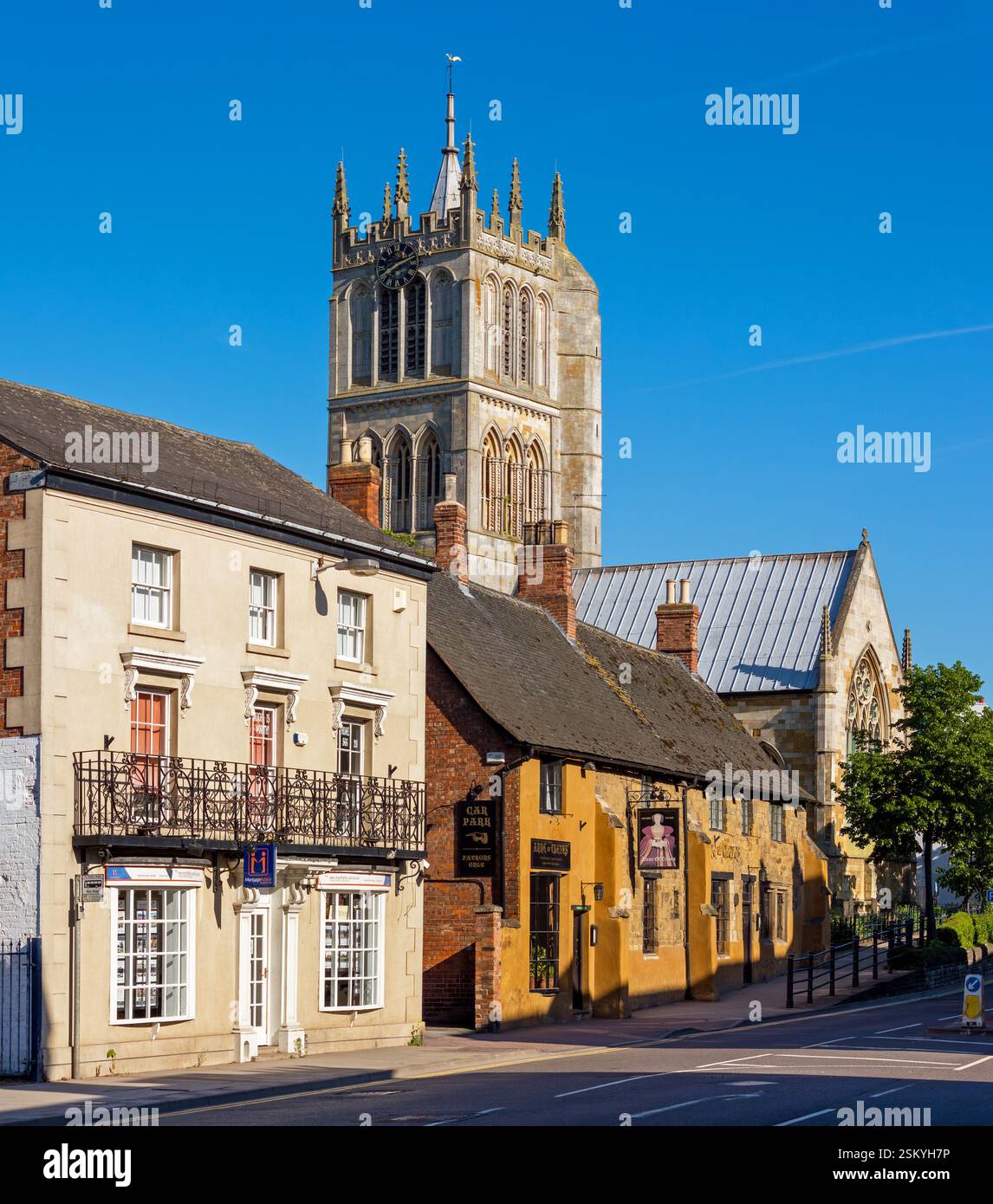 Ladenfronts, Anne of Cleves Public House und St. Marys Church Melton Mowbray an einem sonnigen Tag im Mai mit klarem blauen Himmel, Leicestershire, England, Großbritannien Stockfoto
