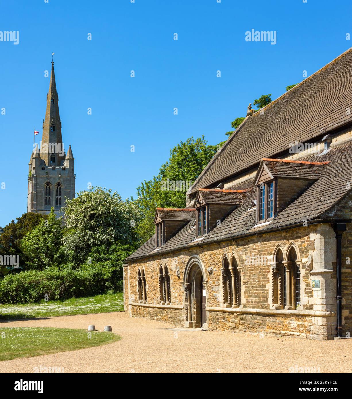 Die große Halle von Oakham Castle und der Turm der All Saints Church an einem sonnigen Oktobertag mit klarem blauem Himmel, Oakham, Rutland, England, Großbritannien. Stockfoto