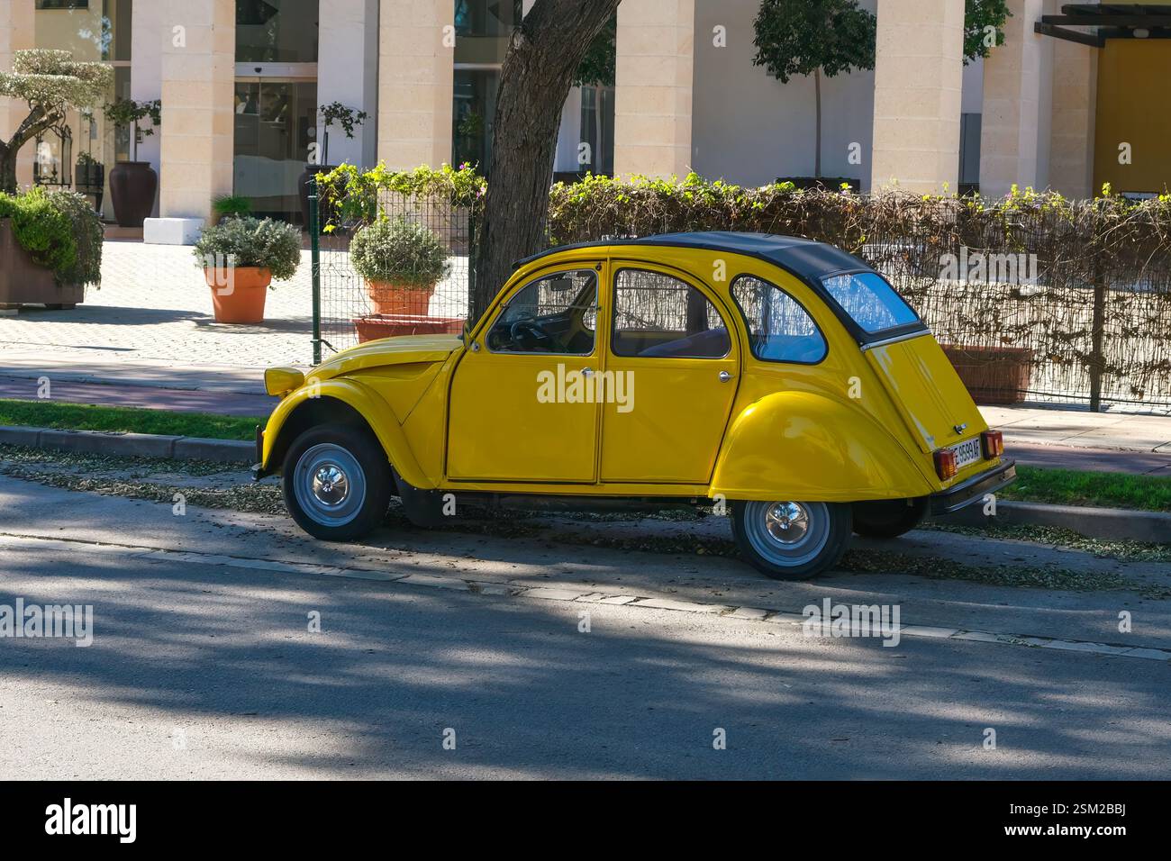 Ein wunderschönes, klassisches, gelbes französisches Auto, das am Straßenrand parkt. Stockfoto