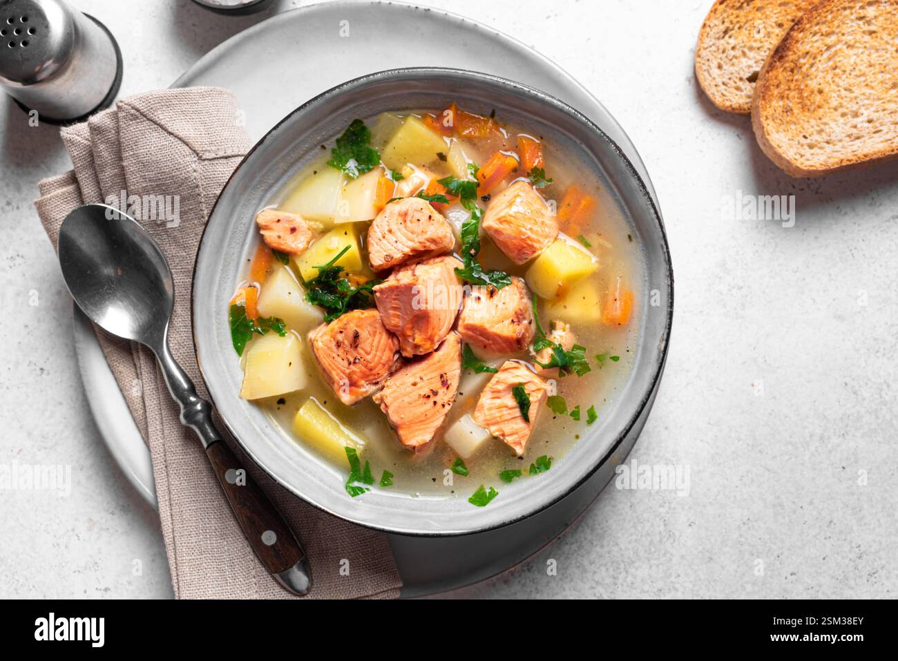 Lachsfischsuppe. Traditionelle Suppe mit rotem Lachs und Gemüse, Blick von oben. Stockfoto