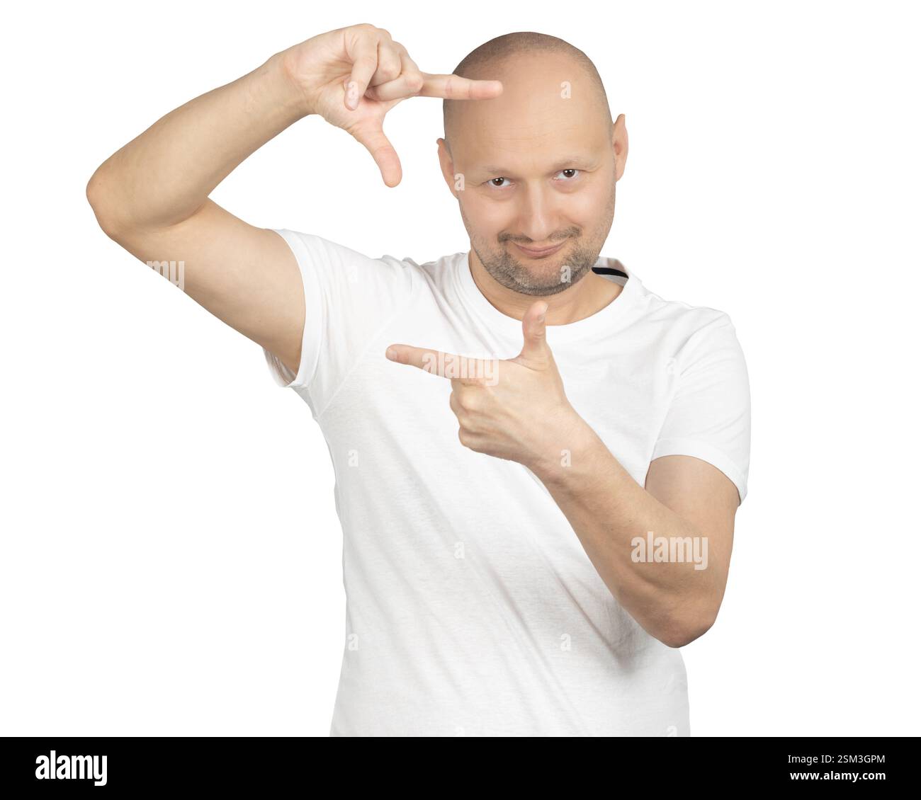 Ein kahler Mann in einem weißen T-Shirt macht mit seinen Händen eine rechteckige Geste, während er verspielt lächelt. Stockfoto