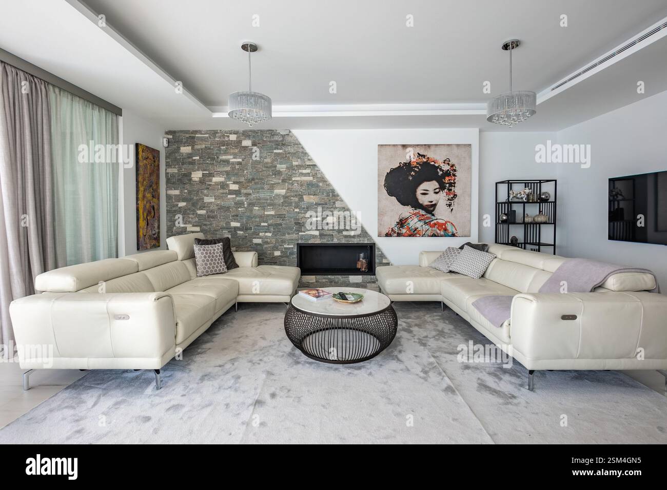 Ein Bild von zwei großen Ledersofas neben einem Kamin im luxuriösen Wohnzimmer der mediterranen Villa Stockfoto