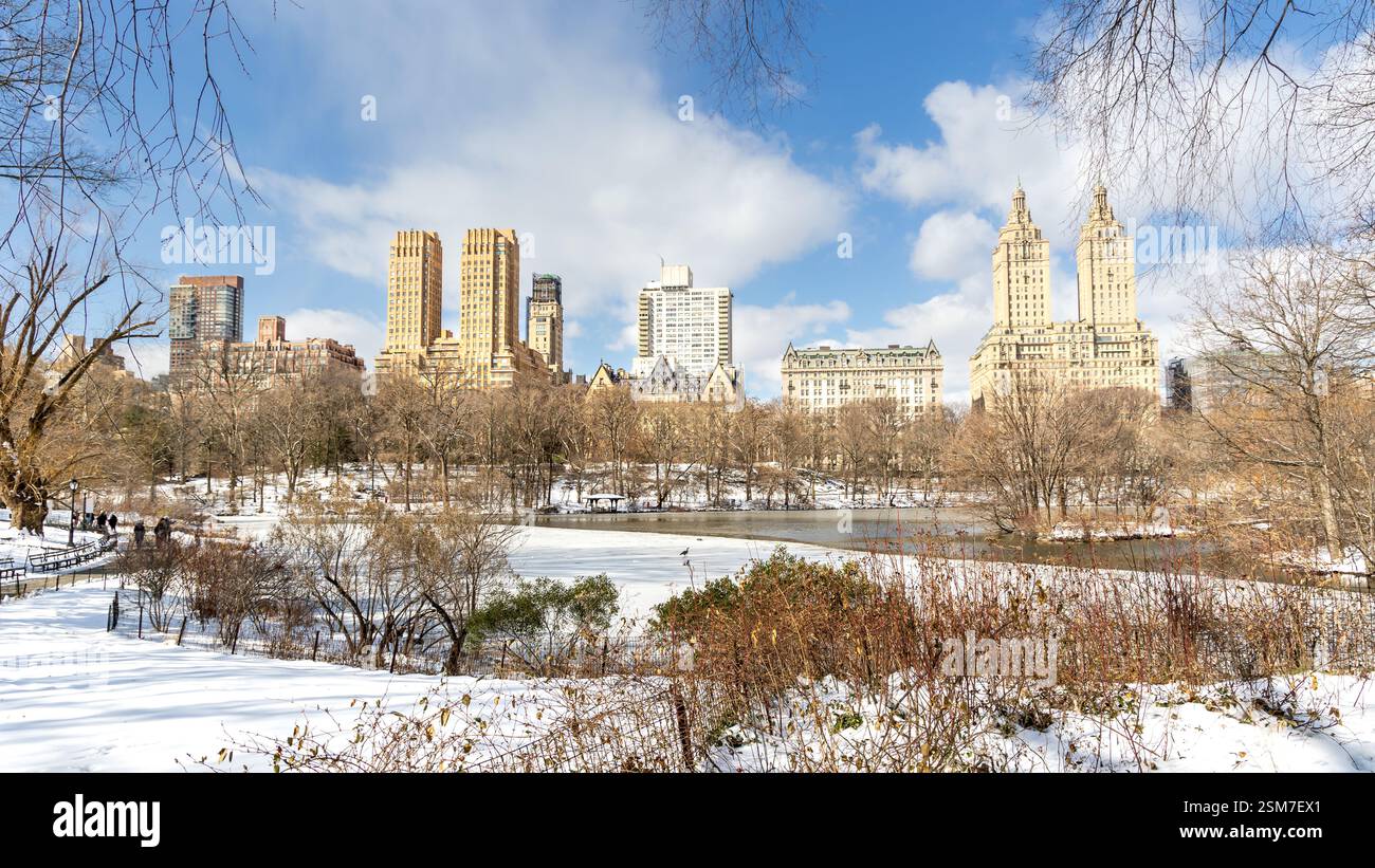 Besucher genießen einen Wintertag im Central Park, während ein gefrorener See die Skyline von New York City im Februar 2025 widerspiegelt. Stockfoto