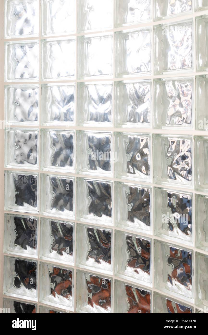 Eine Wand aus Glasblock, durch die Licht hindurchscheint. Hintergrundabstrakt Stockfoto