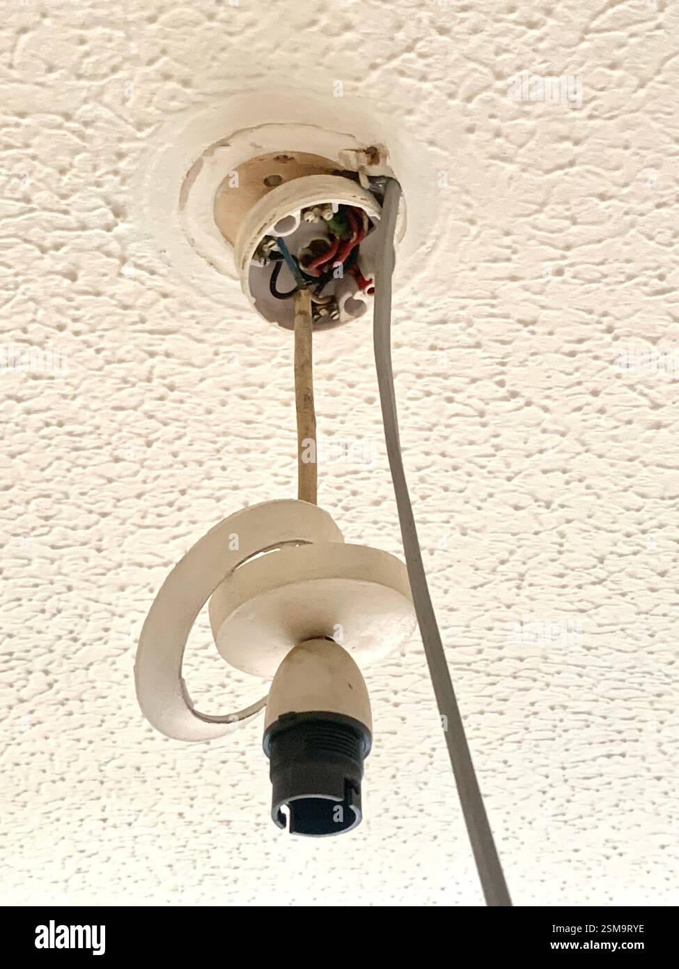 Leuchte innen an einer Decke Britisch Großbritannien Englisch elektrische Leitungen fehlerhaft Rosendraht Kabel Flex Pattress weißes Dachloch - Smartphone-aufgenommenes Stockfoto