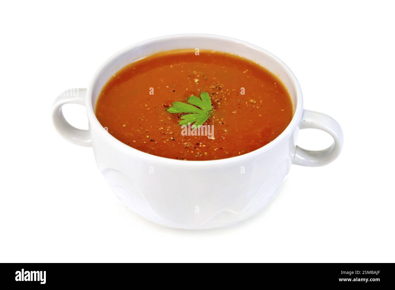 Tomatensuppe in einer weißen Schüssel mit Petersilie, die isoliert auf weißem Hintergrund Stockfoto