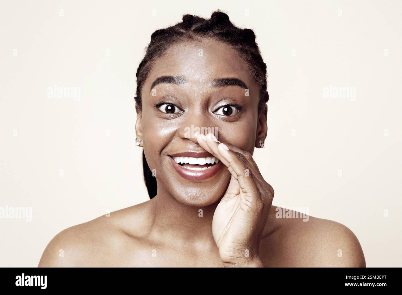 Hübsche schwarze Dame, die Gerüchte teilt und die Handfläche neben den Mund hält Stockfoto