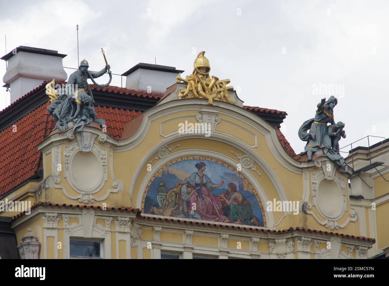 Fassade. Verzierte Stuckarbeiten und Skulpturen schmücken ein Gebäude. Die Figuren auf dem Dach repräsentieren Brandbekämpfung, Mythologie und Krieg. Zeigt eine Szene aus dem tschechischen h Stockfoto