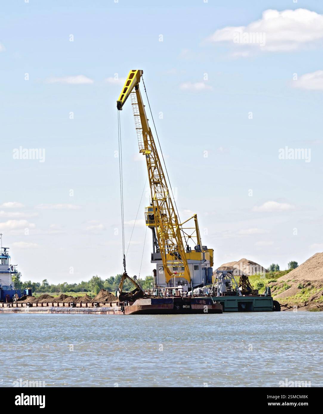 Verladung von Sand mit Hilfe eines Krans auf einem Lastkahn. River White, Russland, Europa Stockfoto