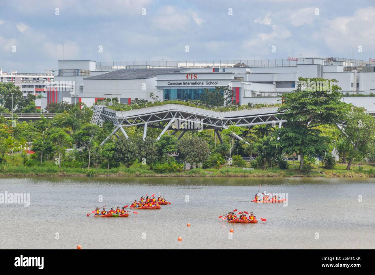 Jurong, Singapur - 17. Februar 2025: Bootstouren im Jurong Lake. Die Canadian International School steht im Hintergrund. Stockfoto