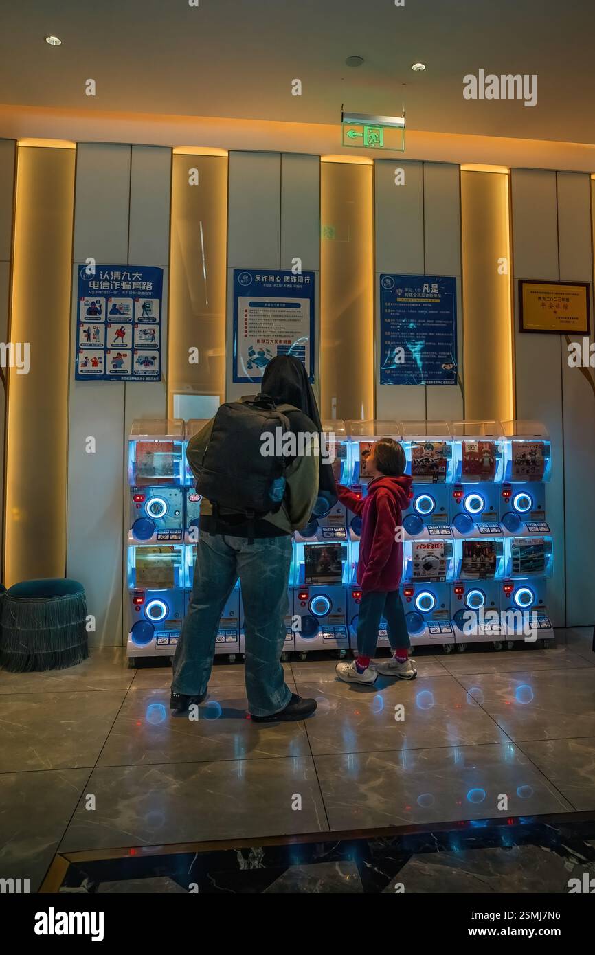 Shanghai, China - 7. Dezember 2024 Kinder schauen sich die Automaten für Spielzeuge für Kapseln im Mercure Hotel an Stockfoto