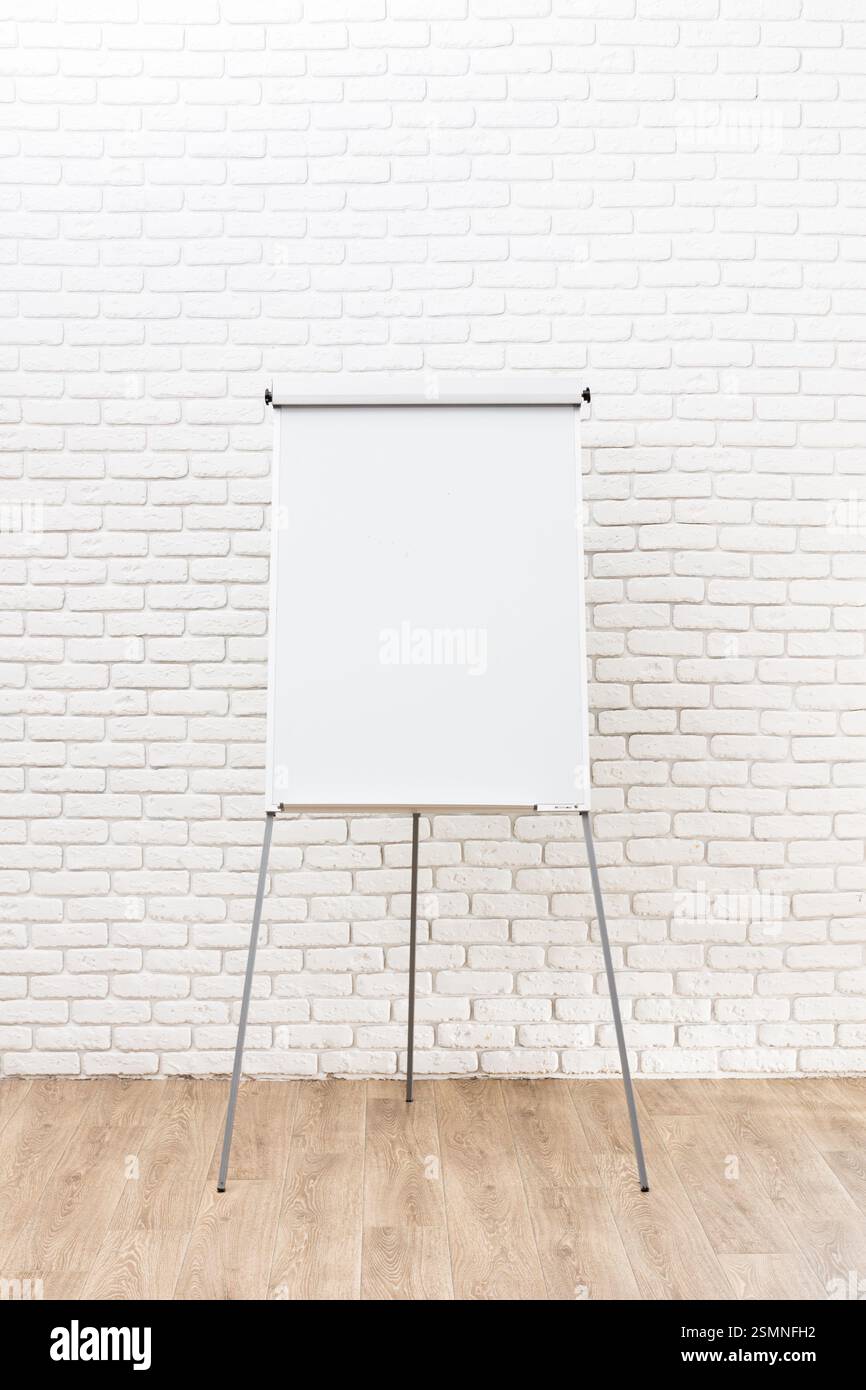Leeres Flipchart in einem hellen Tagungsraum, bereit für Brainstorming und Zusammenarbeit in einer modernen Büroumgebung Stockfoto