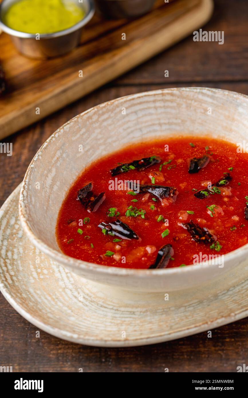 Scharfe mexikanische Tomatensuppe mit getrockneten Chilischoten in einer rustikalen Schüssel Stockfoto