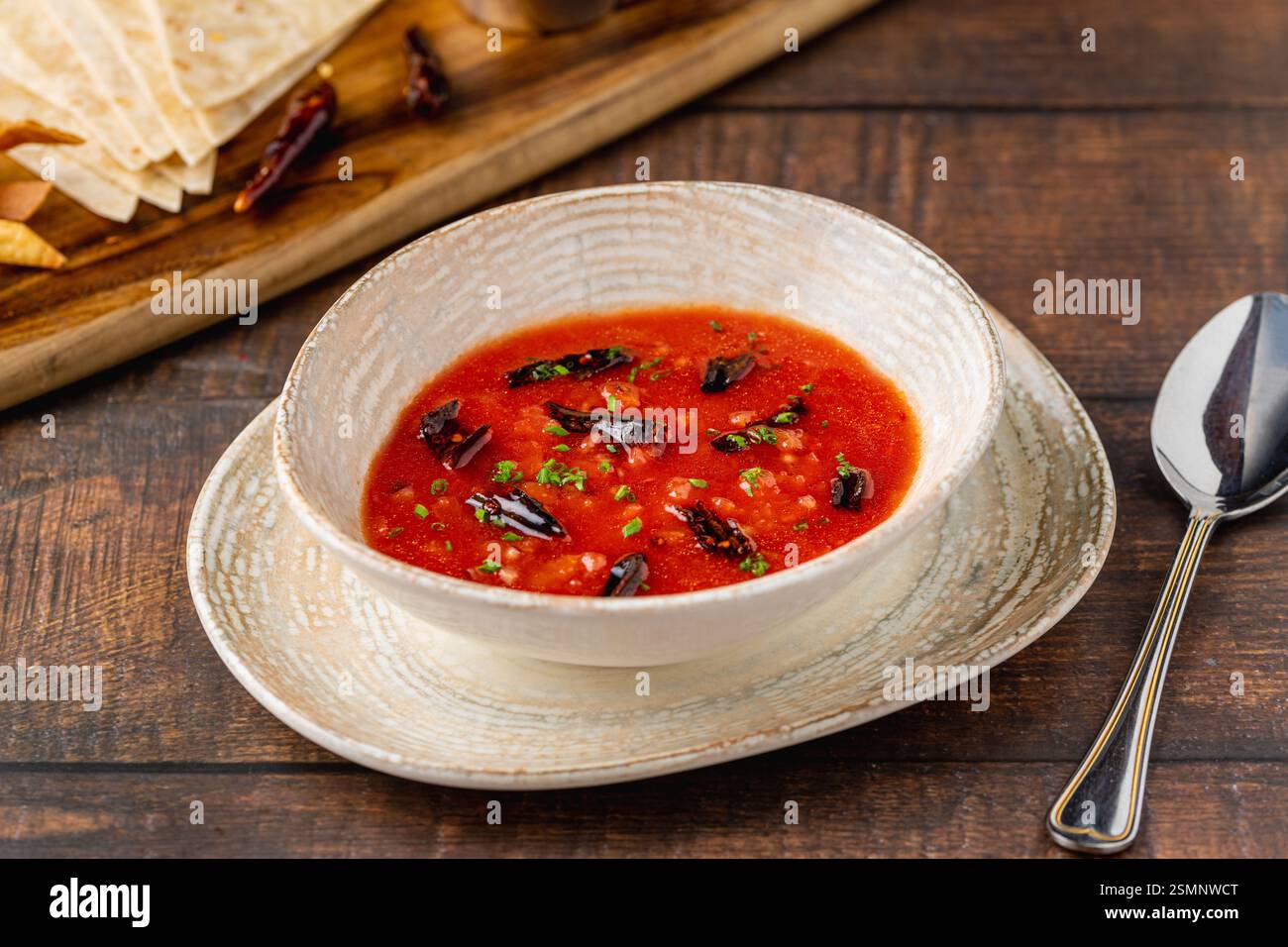 Scharfe mexikanische Tomatensuppe mit getrockneten Chilischoten in einer rustikalen Schüssel Stockfoto