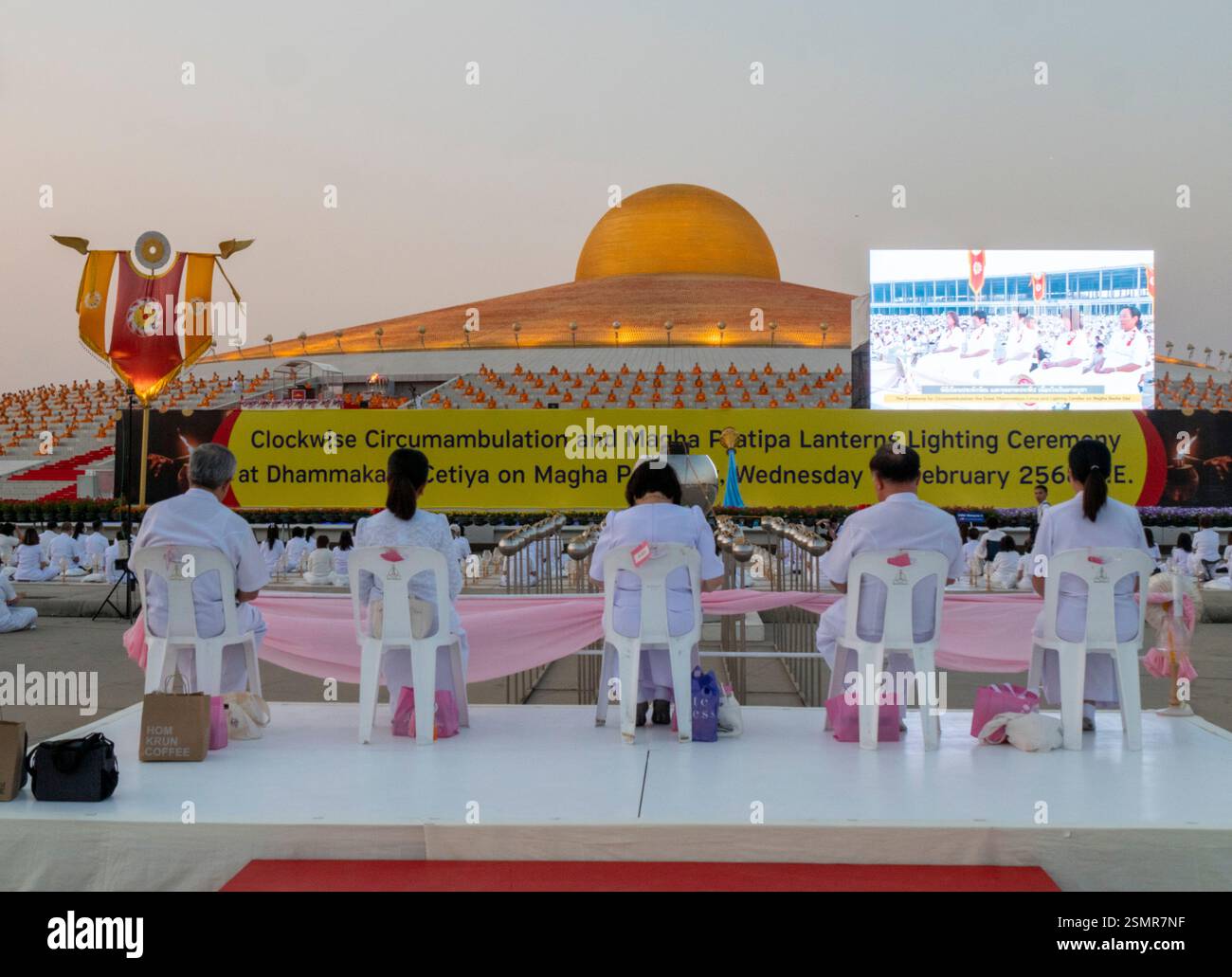 Die Menschen beten während der Zeremonien des Makha Bucha Day im Wat Phra Dhammakaya Tempel weiter. 5.000 buddhistische Mönche und 35.000 Menschen nahmen an dieser jährlichen Veranstaltung Teil. Stockfoto