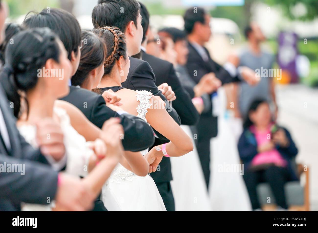 Verschiedene Bräute und Bräutigam wärmen sich an der Startlinie in Vorbereitung auf das Rennen, um zu gewinnen und die Zahlung für ihre ideale Hochzeit zu erhalten. Stockfoto