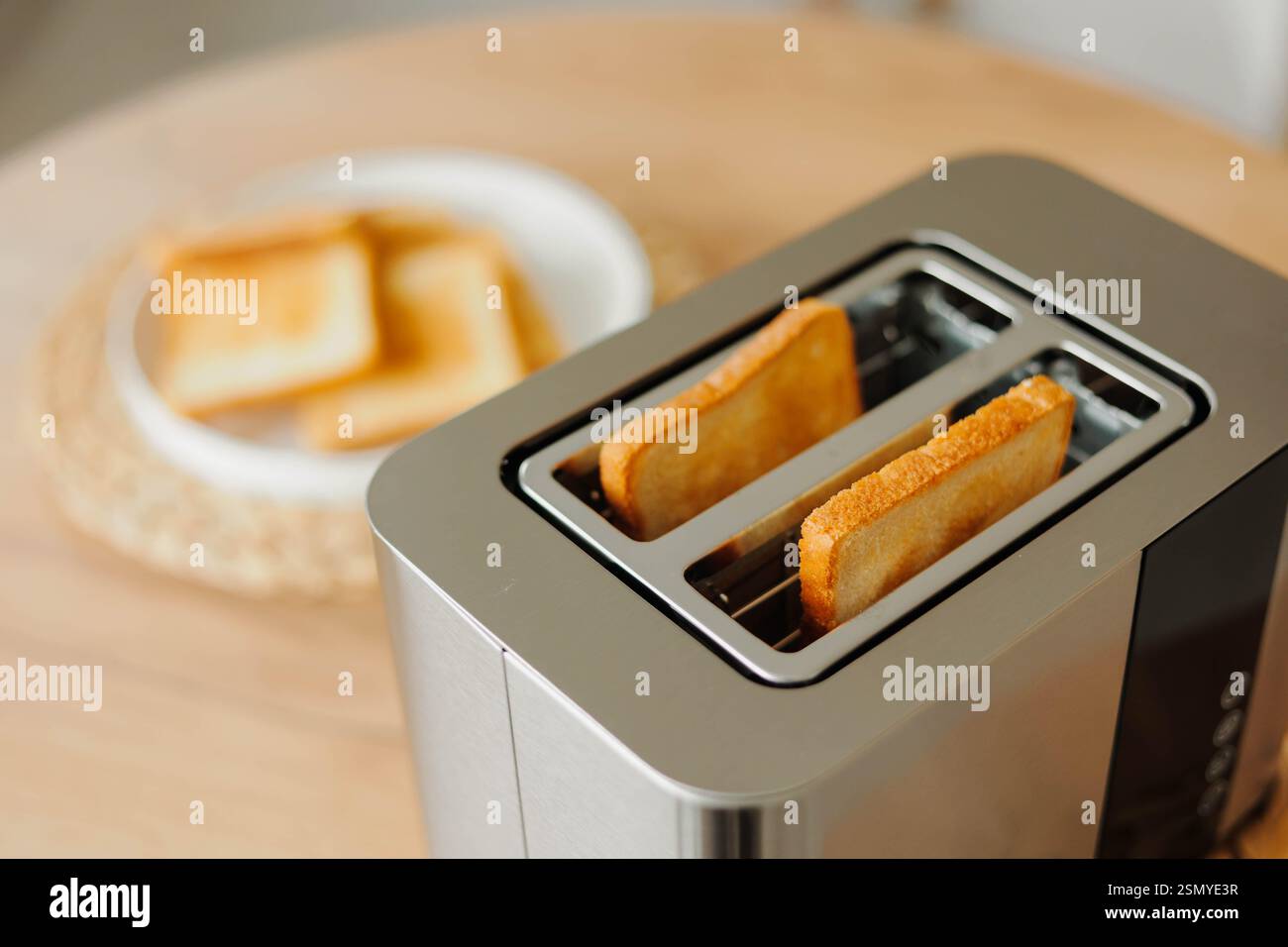Zwei Stücke gebratenes goldenes Brot im Toaster. Morgenmahlzeit. Stockfoto