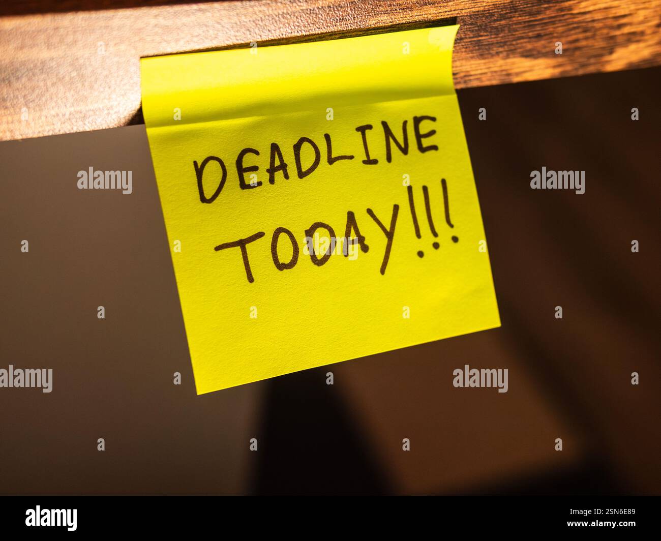Helle Haftnotiz mit einer Erinnerung an die heutige Frist, die auf einem Schreibtisch platziert wird Stockfoto