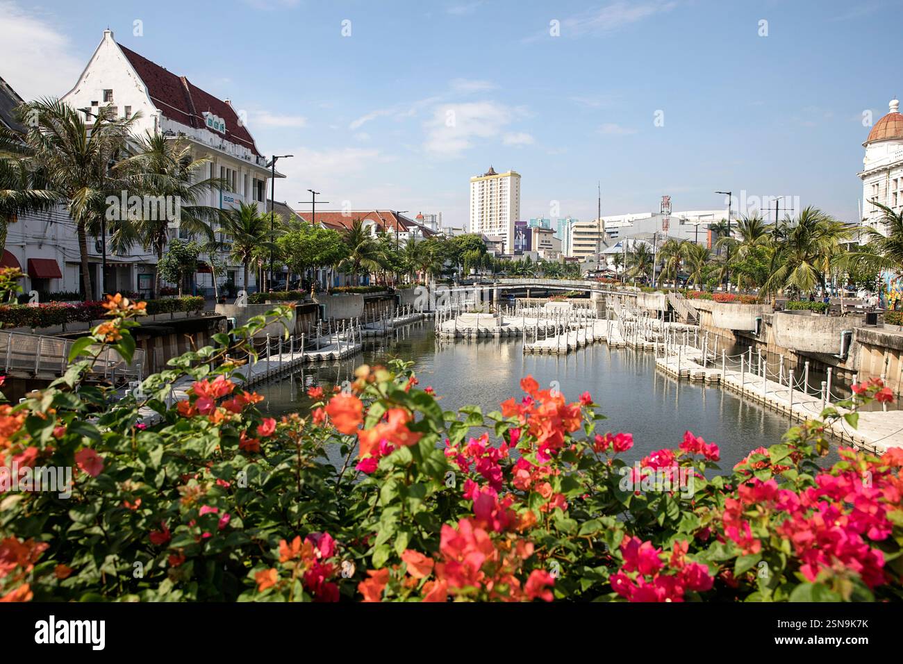 Wunderschöne alte historische Gebäude des alten Teils von Jakarta in Indonesien umgeben von Wasserkanälen, mit wunderschönen Blumen an der Vorderseite. Stockfoto