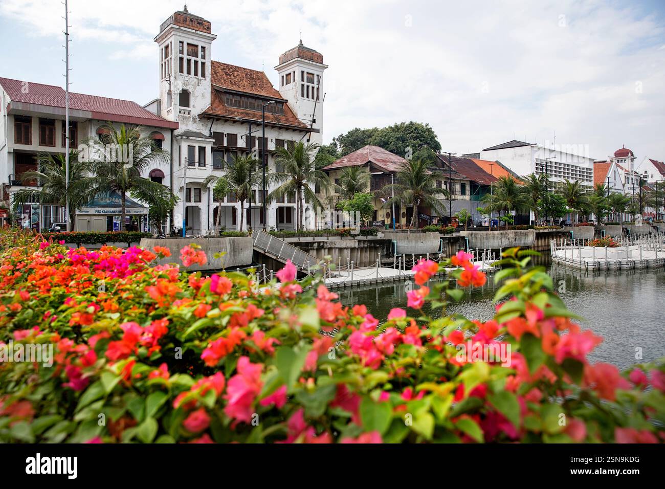 Wunderschöne alte historische Gebäude des alten Teils von Jakarta in Indonesien umgeben von Wasserkanälen, mit wunderschönen Blumen an der Vorderseite. Stockfoto