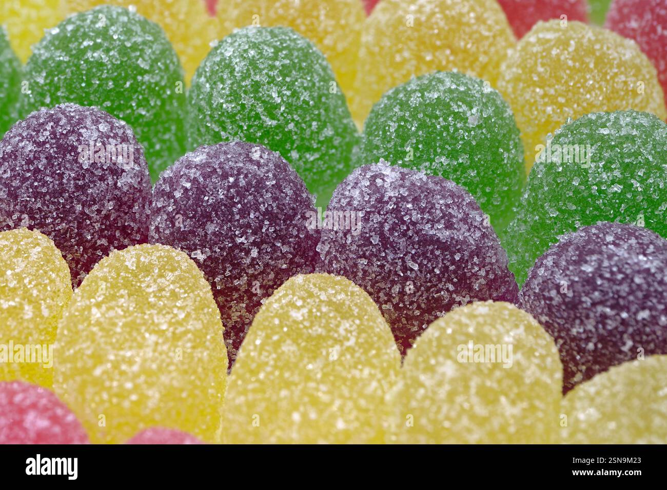 Viele bunte Gummitropfen. Nahaufnahme, abstrakter Essenshintergrund. Stockfoto