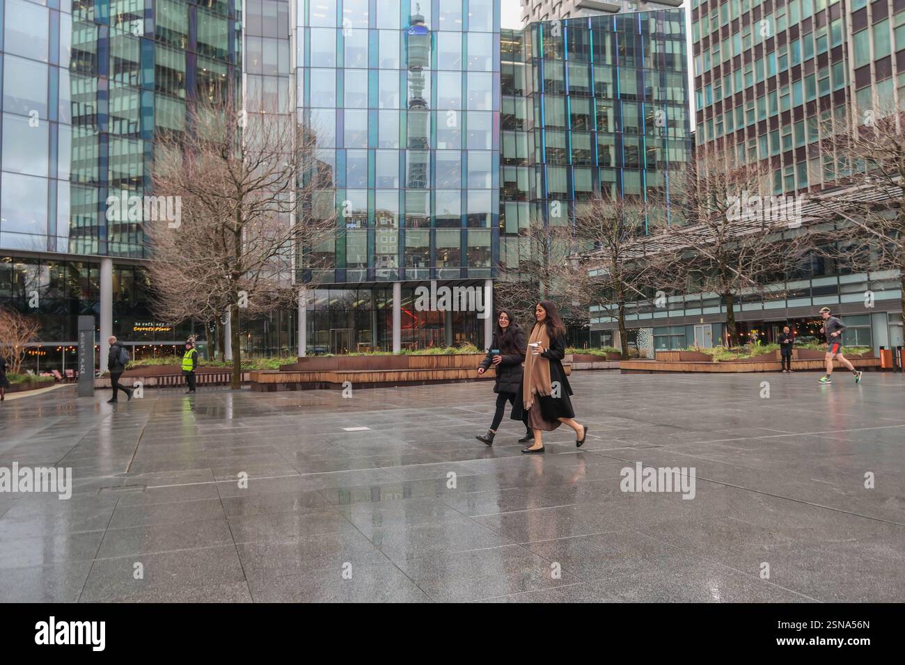 Menschen, die über den Triton Square in London vor verglasten Bürogebäuden laufen Stockfoto