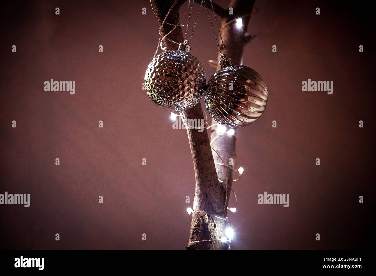 Zwei metallische Weihnachtsschmuck, einer mit einer strukturierten Oberfläche mit Rautenmuster und der andere mit einem gerippten, muschelartigen Muster, Stockfoto